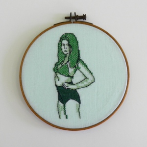 Cross stitch and back stitch embroidery, green woman in big pants.